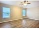 Bedroom features wood-look flooring, neutral paint, ceiling fan, and two windows at 12508 Evington Point Dr, Riverview, FL 33579
