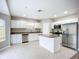 Modern kitchen with stainless steel appliances, granite countertops, and a functional center island at 12508 Evington Point Dr, Riverview, FL 33579