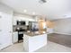 Modern open kitchen featuring stainless appliances and granite counters that flow into the adjacent living spaces at 12508 Evington Point Dr, Riverview, FL 33579