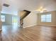 Open living area with stairs, wood-look flooring, and sliding glass doors to the backyard at 12508 Evington Point Dr, Riverview, FL 33579