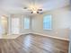 Spacious living room with wood-look flooring, large windows, and modern ceiling fan at 12508 Evington Point Dr, Riverview, FL 33579