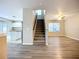 Open-concept living room with wood-look flooring, fan, and staircase at 12508 Evington Point Dr, Riverview, FL 33579