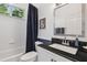 Bathroom with a dark granite countertop, white cabinetry, and a shower-tub combo with a blue shower curtain at 12523 Riverglen Dr, Riverview, FL 33569