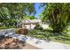 Home with lush landscaping, mature trees, well-maintained lawn, and a spacious driveway leading to a three-car garage at 12523 Riverglen Dr, Riverview, FL 33569