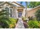 Inviting front entrance with a stone pathway and lush tropical plants at 12523 Riverglen Dr, Riverview, FL 33569