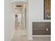 Hallway view leading to a bathroom; features neutral tile flooring and clean, white walls at 12523 Riverglen Dr, Riverview, FL 33569