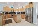 Well-lit kitchen featuring a center island, granite counters, and a stainless steel refrigerator at 12523 Riverglen Dr, Riverview, FL 33569