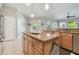 Bright kitchen with a granite island, pendant lighting, and a view into a sitting room at 12523 Riverglen Dr, Riverview, FL 33569