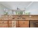 Bright kitchen featuring a stainless steel sink and a granite countertop, seamlessly flowing into the living area at 12523 Riverglen Dr, Riverview, FL 33569
