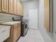 Functional laundry room with lots of cabinetry, utility sink, and modern washer and dryer units at 12523 Riverglen Dr, Riverview, FL 33569