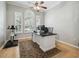 Spacious office with wood floors, a ceiling fan, three windows, and a large desk at 12523 Riverglen Dr, Riverview, FL 33569