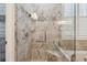 Beautiful tiled shower with glass door, grab bars, seat, and decorative tile accents at 12523 Riverglen Dr, Riverview, FL 33569