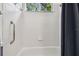 Bright white shower-tub combo with tile, a window view, and a shower curtain at 12523 Riverglen Dr, Riverview, FL 33569