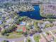 Aerial view of a community showing houses, a lake, a community pool, and tennis courts at 130 Sabal Ct # C, Oldsmar, FL 34677