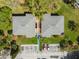 An aerial top-down view of two condos, green lawns, landscaping, parking, and mature trees at 130 Sabal Ct # C, Oldsmar, FL 34677