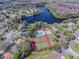 Aerial view of community amenities with tennis courts, pool and clubhouse surrounded by pond and lush landscape at 130 Sabal Ct # C, Oldsmar, FL 34677