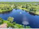 Scenic aerial view of a tranquil lake featuring a fountain, with lush greenery surrounding the water's edge at 130 Sabal Ct # C, Oldsmar, FL 34677