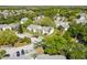 An aerial view of condominium buildings with green lawns, mature trees, and parking areas at 130 Sabal Ct # C, Oldsmar, FL 34677