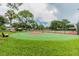 Outdoor community basketball court surrounded by green space and mature trees under a bright sky at 130 Sabal Ct # C, Oldsmar, FL 34677
