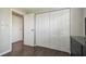 Bedroom featuring wood floors, closet with white bi-fold doors and an adjacent doorway at 130 Sabal Ct # C, Oldsmar, FL 34677