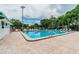 Community pool surrounded by a deck with chairs and lush greenery at 130 Sabal Ct # C, Oldsmar, FL 34677