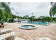 Community pool and hot tub area with lounge chairs and mature landscaping at 130 Sabal Ct # C, Oldsmar, FL 34677