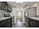 View of the kitchen with stainless steel appliances, backsplash, and dark cabinets leading to the open living area at 130 Sabal Ct # C, Oldsmar, FL 34677