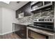 This modern kitchen features stainless steel appliances, a stylish tile backsplash, and elegant dark wood cabinets at 130 Sabal Ct # C, Oldsmar, FL 34677