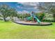 Community playground with slides and climbing structure set on a green lawn at 130 Sabal Ct # C, Oldsmar, FL 34677