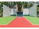 Outdoor shuffleboard court with green and red playing surface enclosed by fencing at 130 Sabal Ct # C, Oldsmar, FL 34677