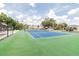 Well-maintained blue and green tennis court with a dark fence, nestled in a green community at 130 Sabal Ct # C, Oldsmar, FL 34677