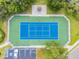 Overhead shot of green and blue tennis court with parking, landscaping, and sidewalk border at 130 Sabal Ct # C, Oldsmar, FL 34677