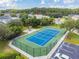 Aerial view of a fenced tennis court surrounded by trees, with a gazebo and parking available at 130 Sabal Ct # C, Oldsmar, FL 34677