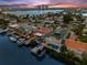 Breathtaking aerial view of waterfront home, private dock, pool, lush landscaping, and stunning sunset skies at 139 Wall St, Redington Shores, FL 33708