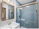 Bathroom featuring blue tile shower and modern vanity mirror combo with a white sink at 139 Wall St, Redington Shores, FL 33708