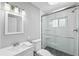 Modern bathroom with white vanity, toilet, and a walk-in shower enclosed with glass and finished with modern tile at 139 Wall St, Redington Shores, FL 33708