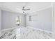 Bright bedroom with white marble floors, ceiling fan, and a window offering plenty of natural light at 139 Wall St, Redington Shores, FL 33708
