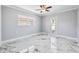 Bright bedroom with marble floors, ceiling fan, and windows that allow for ample natural light and exterior views at 139 Wall St, Redington Shores, FL 33708