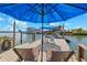 Waterfront dock featuring lounge chairs, a boat lift, and seating under a blue umbrella at 139 Wall St, Redington Shores, FL 33708