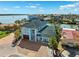 Aerial view of a charming two-story home featuring a green roof, waterfront access, and a brick driveway at 139 Wall St, Redington Shores, FL 33708
