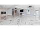 Open living room with marble floors, fireplace, TV, and access to other rooms at 139 Wall St, Redington Shores, FL 33708