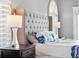 Elegant main bedroom with tufted headboard, two bedside lamps and plantation shutters at 139 Wall St, Redington Shores, FL 33708