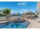 Backyard pool featuring a hot tub, pergola with outdoor seating and water views at 139 Wall St, Redington Shores, FL 33708