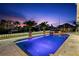 Sparkling pool with ambient lighting, lush greenery, and waterfront views at twilight at 139 Wall St, Redington Shores, FL 33708