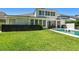 Manicured lawn meets private pool with modern fence and outdoor lounging space, offering a serene retreat at 14705 Canopy Dr, Tampa, FL 33626