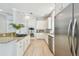 Bright and open kitchen with stainless steel appliances, white cabinetry, subway tile backsplash, and wood flooring at 14705 Canopy Dr, Tampa, FL 33626