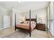 Elegant main bedroom with four-poster bed, hardwood floors, and an ensuite bathroom at 14705 Canopy Dr, Tampa, FL 33626
