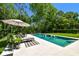 Sparkling pool with ample patio space, umbrella, and manicured lawn at 14705 Canopy Dr, Tampa, FL 33626