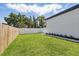 Spacious, fenced backyard with green grass and minimalist landscaping and modern home at 1514 55Th N Ave, St Petersburg, FL 33703