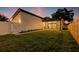 Large, fenced backyard with lush green grass and a modern home exterior at sunset at 1514 55Th N Ave, St Petersburg, FL 33703